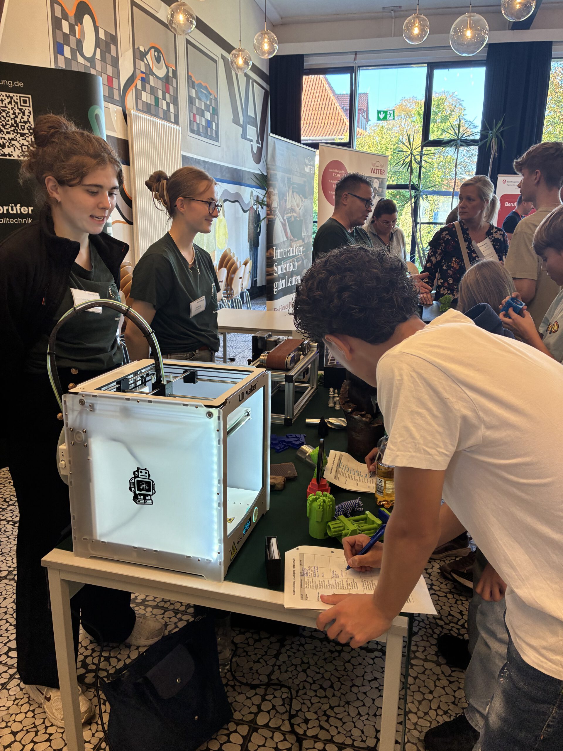 Auszubildende der Firma Baker Hughes präsentieren den Schüler:innen verschiedene Ausbildungsberufe auf der Jobmesse der Schule im Allertaller.